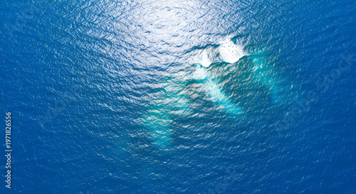 Aerial view of vibrant blue ocean water with sunlight reflecting