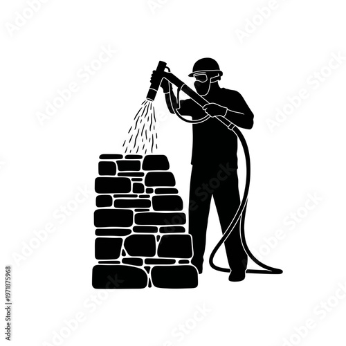 Construction Worker Silhouetted: A construction worker, safely equipped with protective gear, meticulously sprays a stone structure.