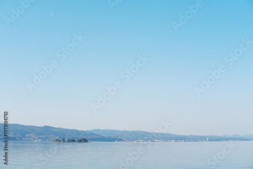 静穏な湖面に映る山々、月影と島々が織りなす水辺の風景