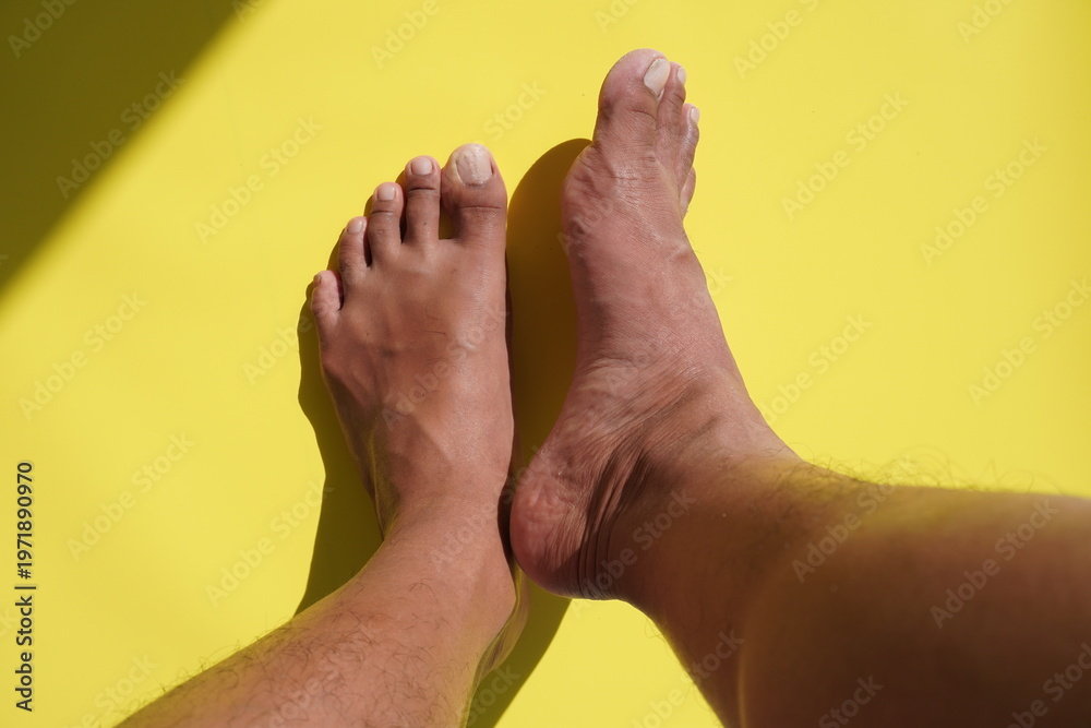 Fototapeta premium Close up view of Asian man's feet on yellow background