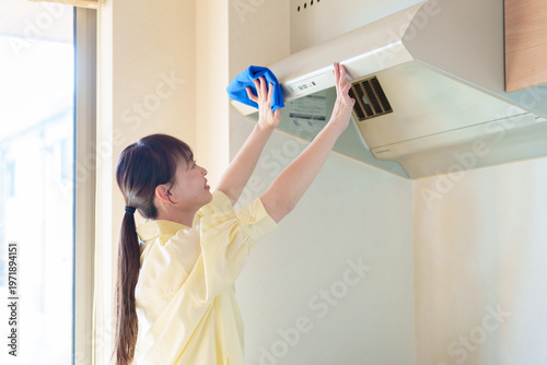 レンジフードを掃除する女性