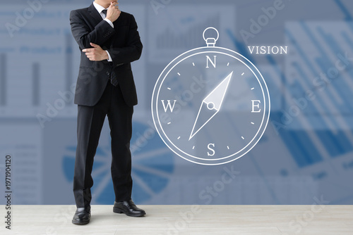 会社や企業のビジョンや経営の方向性を考えるビジネスマンと方位磁針