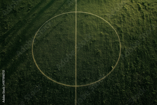 Aerial view of football field center circle on green grass with natural texture and symmetry creating sports background and outdoor concept
