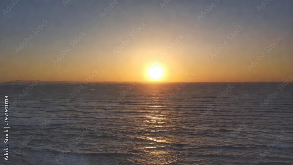 Fototapeta premium Golden sun sets over calm ocean waves