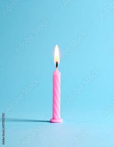 A single pink spiral candle with a lit flame against a light blue background