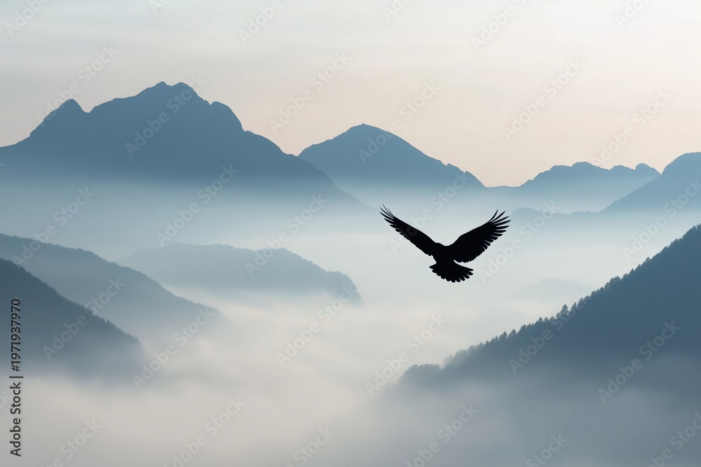 Obraz premium Eagle silhouette soaring over valleys filled with fog and haze, depicting freedom, power, and nature's beauty