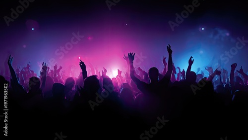Energetic crowd with hands raised under vibrant purple and blue lights