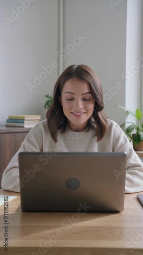 Young woman using laptop for telehealth appointment at home, vertical footage