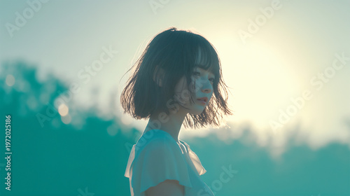 夕焼けの草原に立つ女性