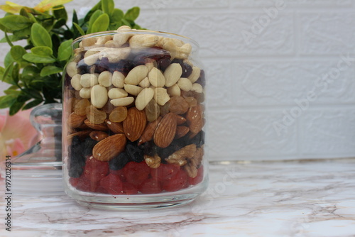 a mix of nuts and fruits in a jar on the table