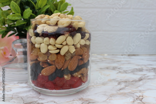 a mix of nuts and fruits in a jar on the table