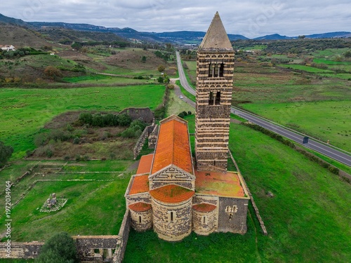 Aerial view of Basilica di Saccargia. Apse and striped bell tower in Sardinia, Italy