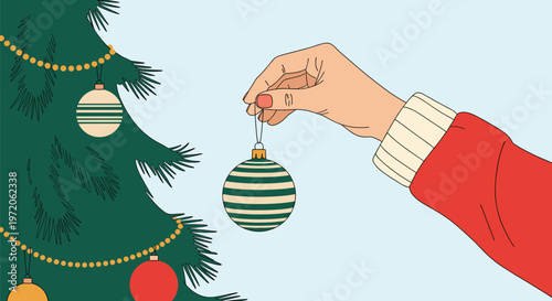 Hand placing a green and white striped bauble on a dark green christmas tree decorated with red and gold ornaments and beaded garlands.