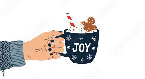 Hand holding a dark blue ceramic mug of hot chocolate topped with marshmallows and a gingerbread man cookie with the word joy on the front.