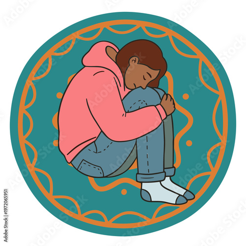 A young person sits sad on the ground with knees up.