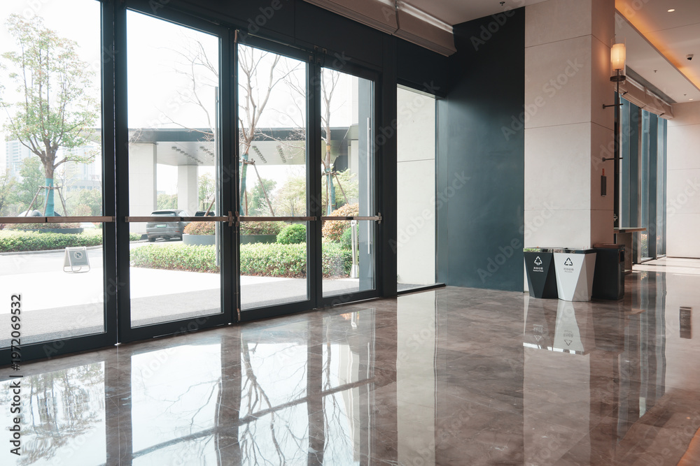 Fototapeta premium Modern interior corridor with glass doors and polished marble flooring reflecting natural light