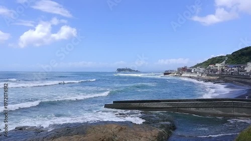 夏休みのイメージ - サーファーが波と戯れる夏真っ盛りの湘南・鎌倉の海と、美しい江ノ島の風景
