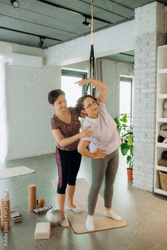 Foto Two women engage in a gentle yoga practice in a bright, airy studio