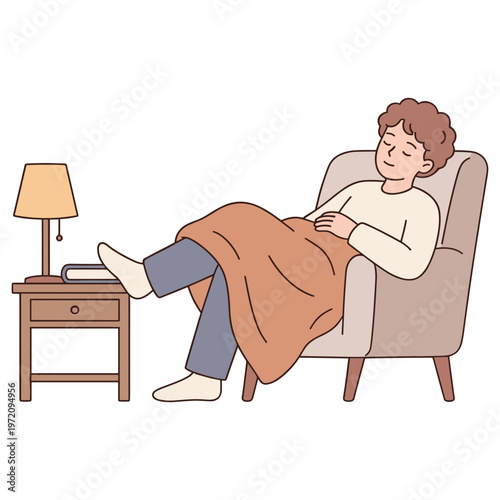 A woman sits comfortably in a chair with a blanket on her lap next to a small table and lamp.