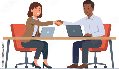 Two business colleagues shake hands over laptops on a table indoors