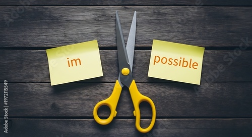 A pair of scissors cutting through two pieces of paper with impossible and possible written on them.
