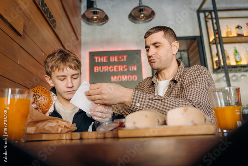 Photos A man and a boy sit at a table in a restaurant