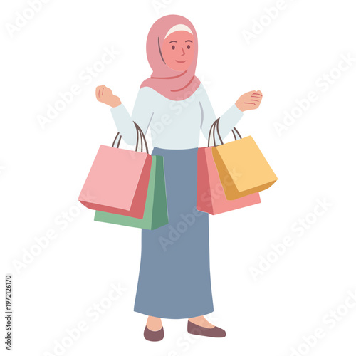 A smiling woman wearing a hijab holds shopping bags while standing.