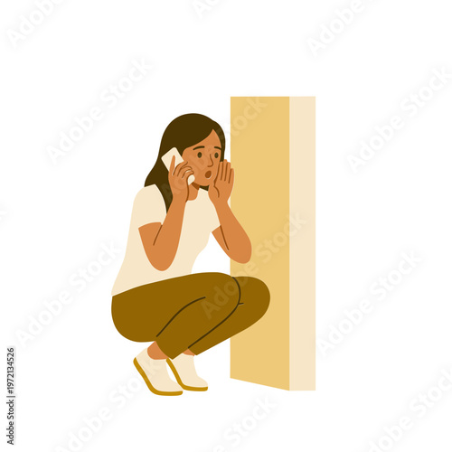 Woman crouches behind wall talking on phone in distress