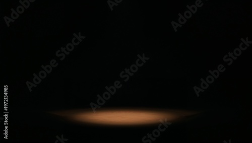 Dark Empty Stage with Focused Warm Spotlight Creating Dramatic Atmosphere
