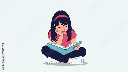 Cute young girl with long dark hair and a pink headband sits cross legged on the floor while intently reading a large blue storybook.