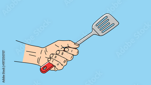 Close up of a human hand firmly holding a metal cooking spatula with a red handle against a light blue background.