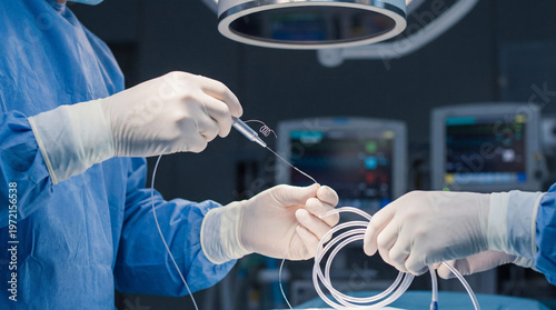 Close-up of medical professionals in surgical gloves preparing a catheter and guidewire for a procedure in an operating room