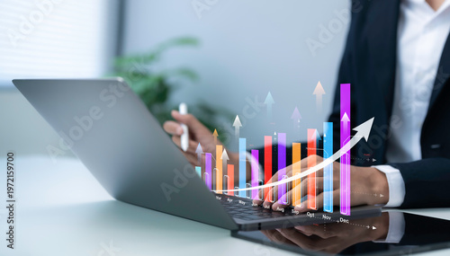Business professional using laptop with financial growth chart hologram showing data analysis performance increase strategy planning digital analytics dashboard trend forecast