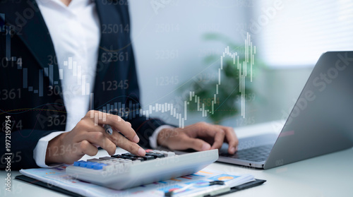 Business professional using calculator and laptop for financial analysis showing stock market data trading chart investment strategy and accounting calculation in modern finance workspace