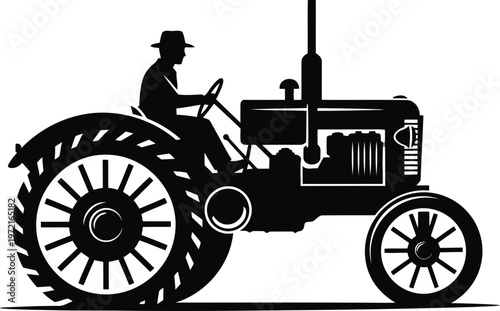 Silhouette of a farmer wearing a hat driving an oldfashioned tractor with large rear wheels