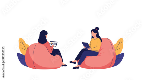 Two female colleagues sitting in pink bean bag chairs having a casual business meeting and discussing work using digital tablets in office.