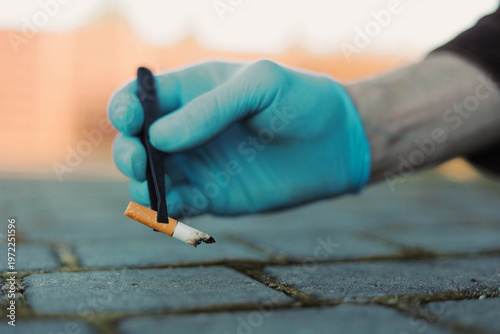 Tablou pe pânză Forensic investigator in gloves collecting cigarette butt with tweezers at crime scene