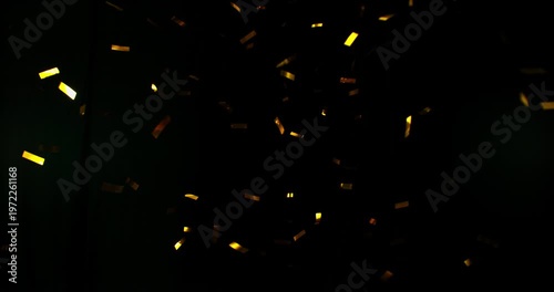 Golden confetti flying in super slow motion against a black background. Shiny metallic particles drifting and falling in the air, creating elegant festive atmosphere with dramatic lighting.