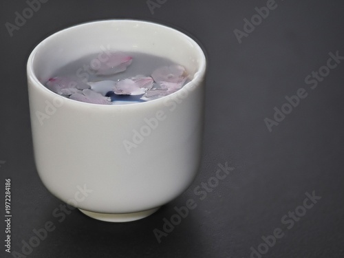 Tokyo, Japan - April 1, 2026: Closeup of Sakura cherry blossom petals in Sake cup

