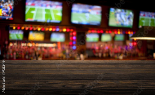 Картината върху платно wooden table on foreground and blurred background depicts the lively interior of