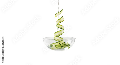 Fresh cucumber slices spiraling into a glass bowl with water droplets falling, isolated on transparent background