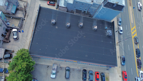 Commercial rooftop cluster near S 12th St and Snyder Ave features HVAC lined structures embedded in dense neighborhood blocks, crowded street. Dark roof membranes, metal units, Philadelphia, PA