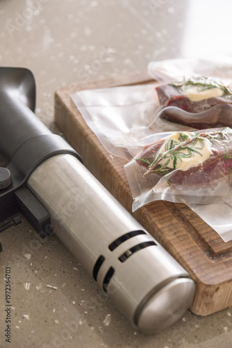 Raw beef steaks with rosemary and butter in vacuum bags with sous vide immersion circulator