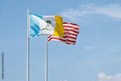 Flags of Penang and Malaysia waving proudly under a clear blue sky
