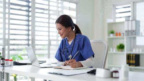 Asian adult female medical professional nurse doctor work laptop digital data healthcare records study online telemedicine consultation clinic office