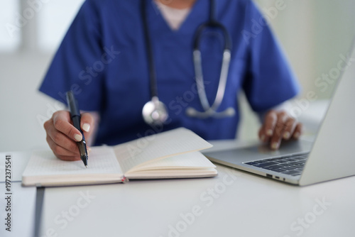 Adult Asian healthcare professional hands document notes laptop patient records medical informatics hospital clinic digital health data management