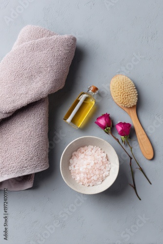 Bath items placed with towel oil brush bowl of salt and roses