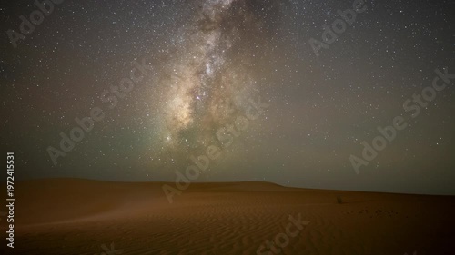 Wide angle time lapse of night Stars milky way moving across night sky in empty desert sand dune in the winter.