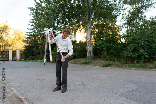 Astronomer Carrying Telescope Tripod On Quiet Outdoor Street