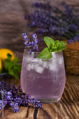A glass of homemade lavender lemonade. Garnished with mint and lavender sprigs.